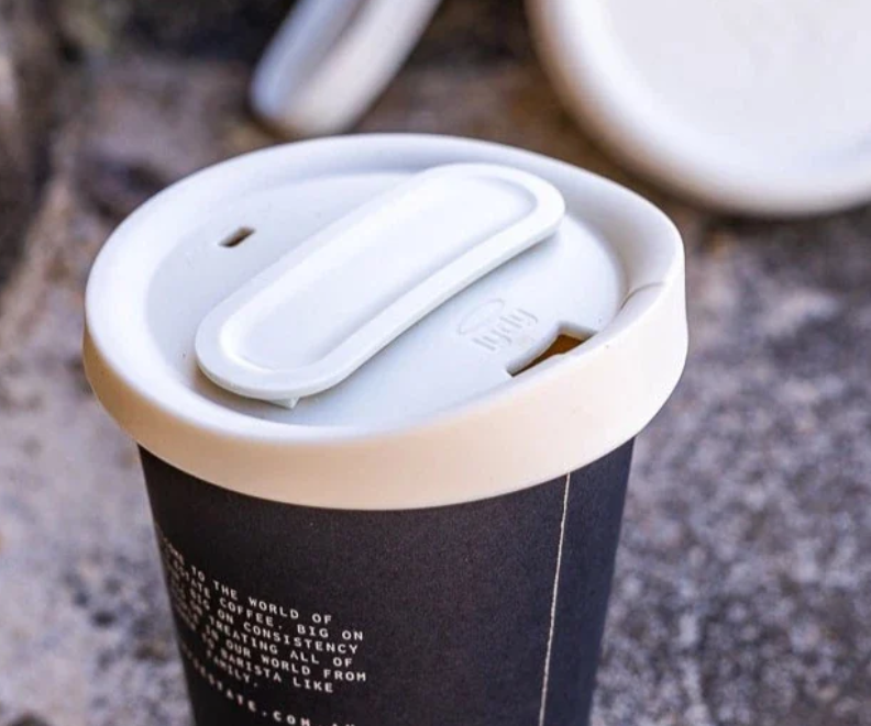 Reusable silicone takeaway cup lid fitted to a coffee cup, designed to replace disposable drink lids.