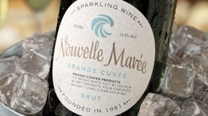 Nouvelle Marée sparkling wine glass bottle with a white paper label resting in an ice bucket.